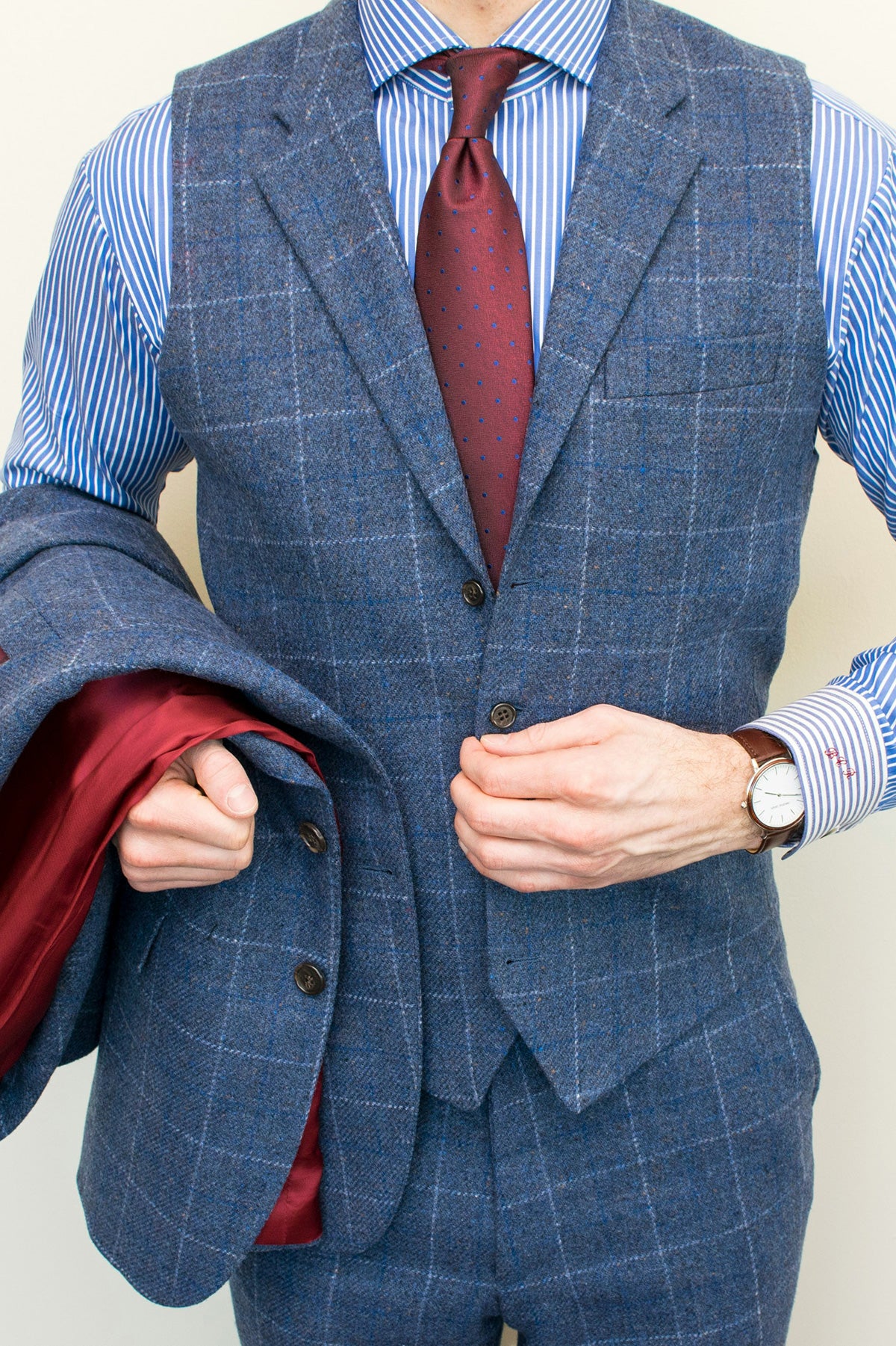 maroon tie Dark grey pliad suit and blue stripes shirt  on a men 