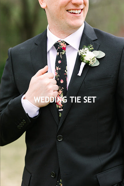 Men wearing black wedding suit black floral mens necktie and floral lapel pin 
