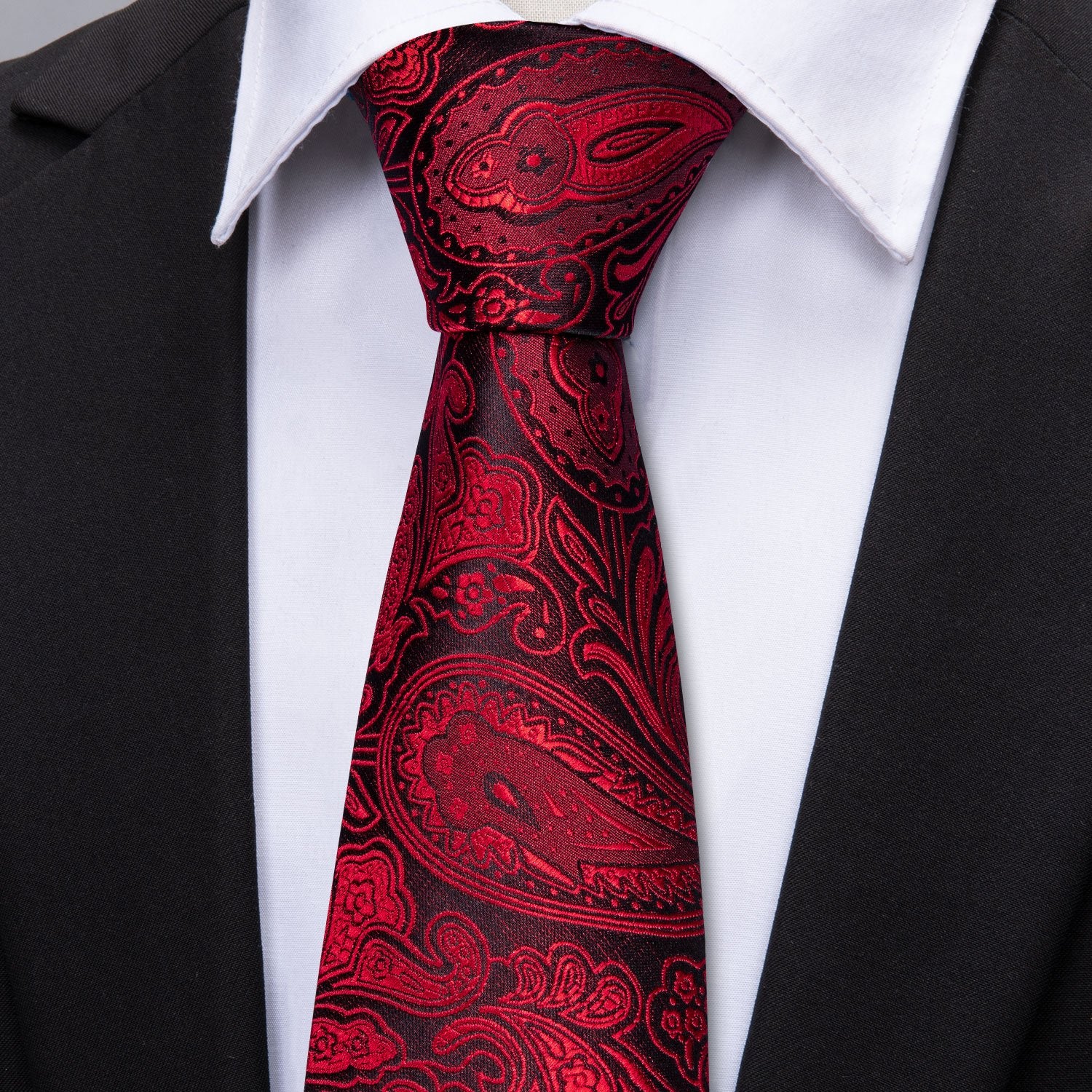 black suit whte shirt and black red paisley necktie 